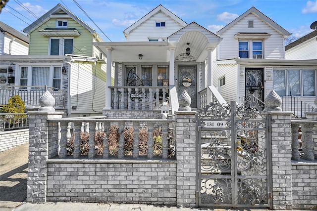 view of front of house featuring a fenced front yard, a porch, and a gate