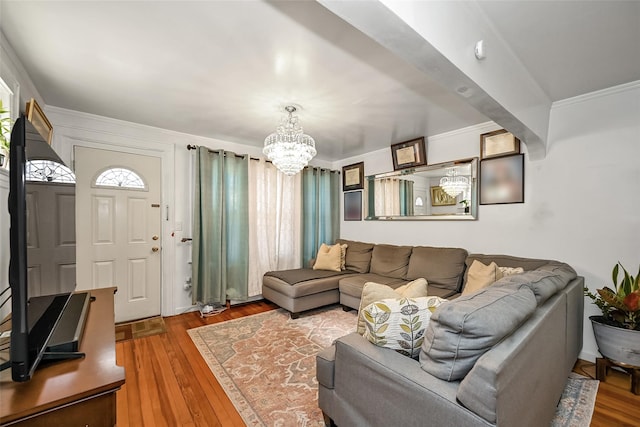 living area featuring a chandelier, crown molding, and hardwood / wood-style flooring