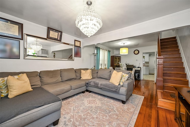 living area featuring stairway, dark wood-style floors, a chandelier, and crown molding