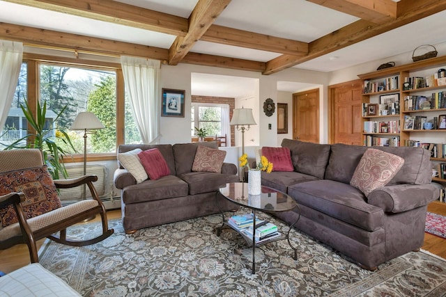 living room featuring beamed ceiling and wood finished floors