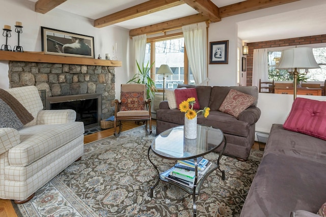 living room featuring beam ceiling, wood finished floors, and a fireplace