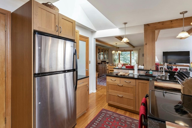 kitchen with an inviting chandelier, light wood-style flooring, freestanding refrigerator, pendant lighting, and dark countertops