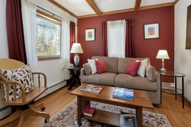 living area featuring a baseboard heating unit, light wood-style flooring, baseboards, and beamed ceiling