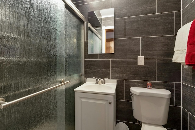 full bath featuring vanity, a shower stall, toilet, and tile walls