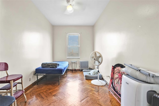 interior space featuring baseboards, ceiling fan, and radiator heating unit