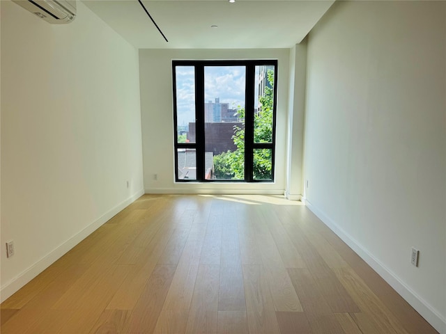 108-15 72nd Ave Unit 5A, Forest Hills, NY 11375 - unfurnished room featuring a wall mounted AC, light wood-type flooring, and baseboards
