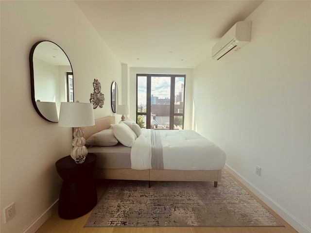 108-15 72nd Ave Unit 5A, Forest Hills, NY 11375 - bedroom featuring an AC wall unit, baseboards, and wood finished floors