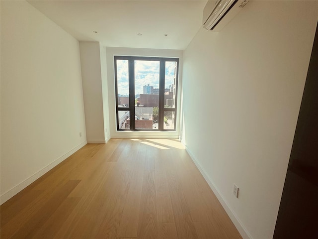 108-15 72nd Ave Unit 5A, Forest Hills, NY 11375 - spare room with a wall mounted AC, light wood finished floors, and baseboards