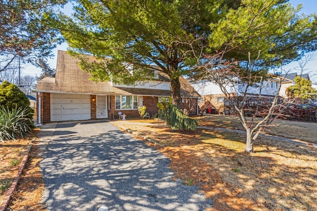 view of front of property with a garage, brick siding, and driveway