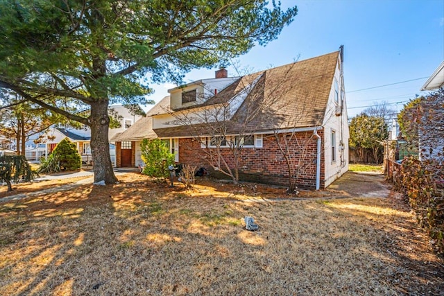 exterior space featuring brick siding and a chimney