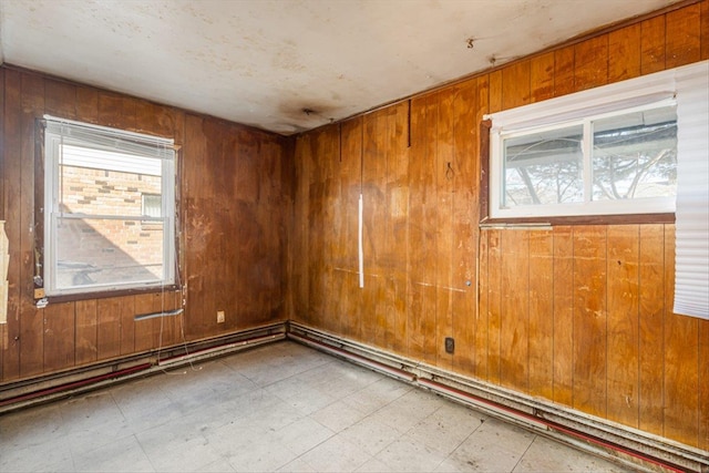 spare room featuring tile patterned floors and wooden walls