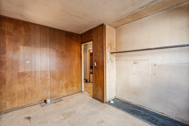 spare room featuring tile patterned floors and wooden walls