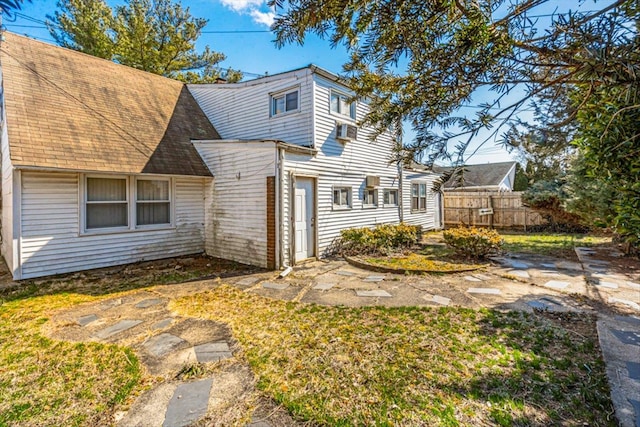 exterior space with a shingled roof and fence