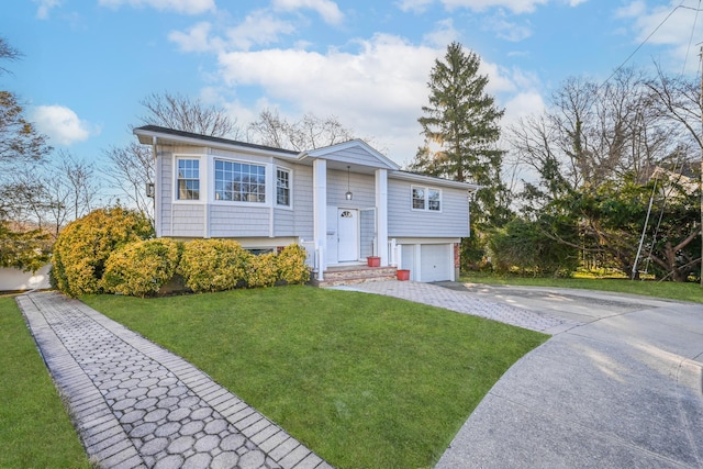 bi-level home with driveway, an attached garage, and a front yard