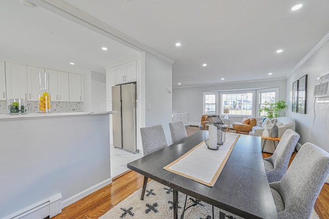 dining space featuring recessed lighting, crown molding, light wood finished floors, a baseboard radiator, and baseboards