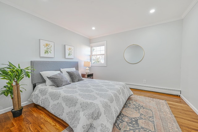 bedroom with ornamental molding, wood finished floors, baseboards, and a baseboard radiator