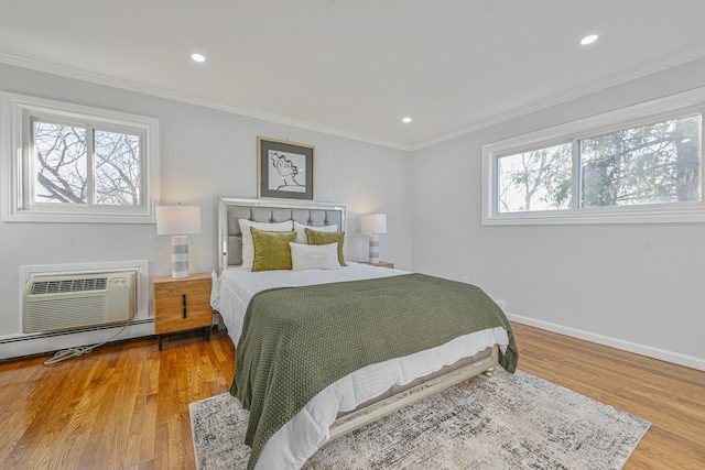 bedroom with ornamental molding, a baseboard heating unit, wood finished floors, recessed lighting, and baseboards