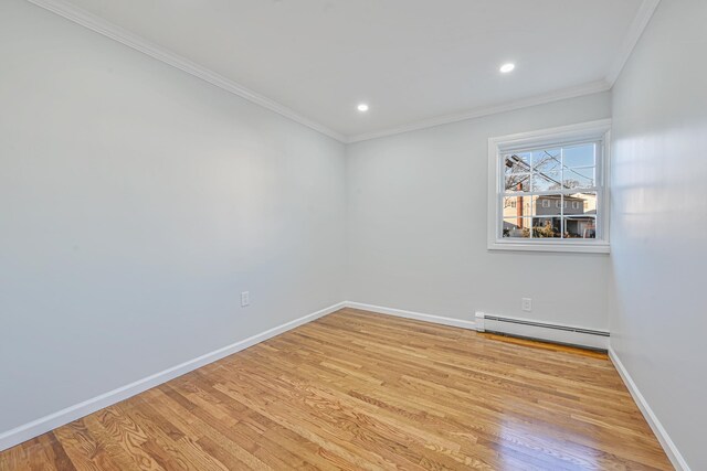 spare room featuring light wood-style flooring, ornamental molding, a baseboard heating unit, recessed lighting, and baseboards