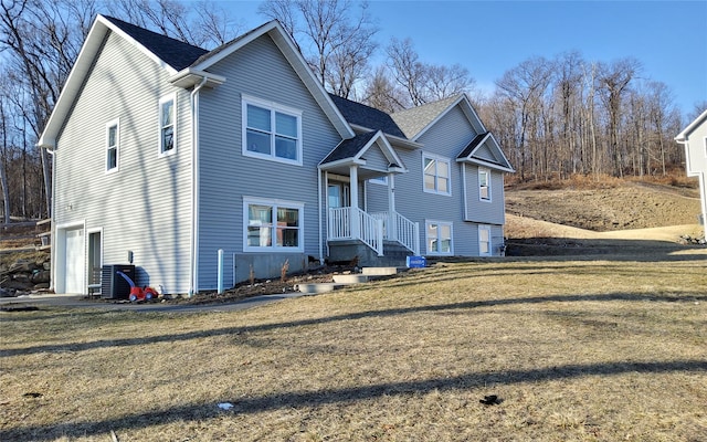 view of front facade featuring a garage, central AC, a front lawn, and a shingled roof