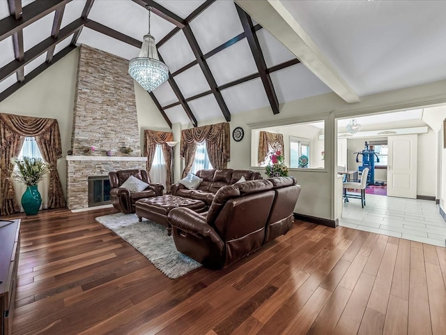 living room featuring a notable chandelier, a stone fireplace, high vaulted ceiling, and wood-type flooring