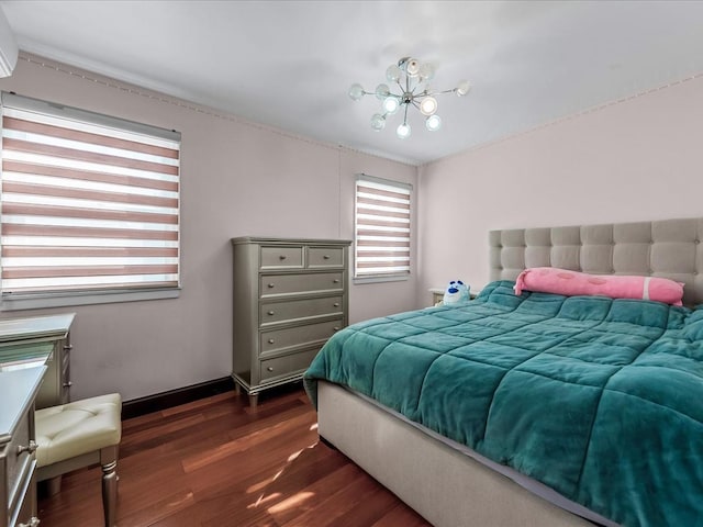 bedroom featuring a chandelier and dark wood-style flooring