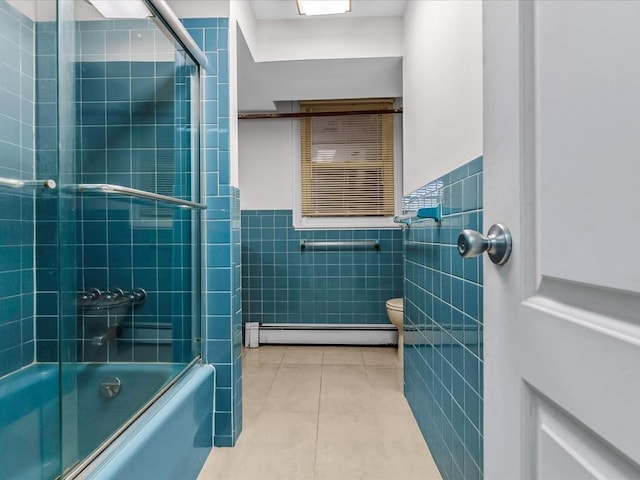 bathroom featuring a baseboard radiator, wainscoting, tile walls, combined bath / shower with glass door, and tile patterned floors