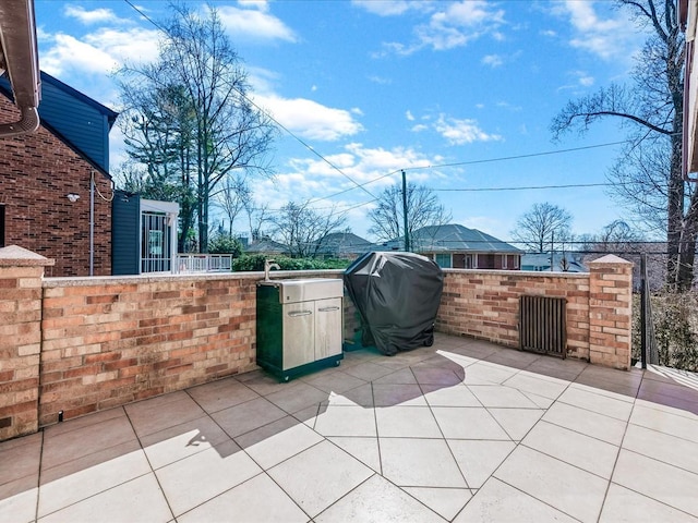 view of patio with area for grilling and fence