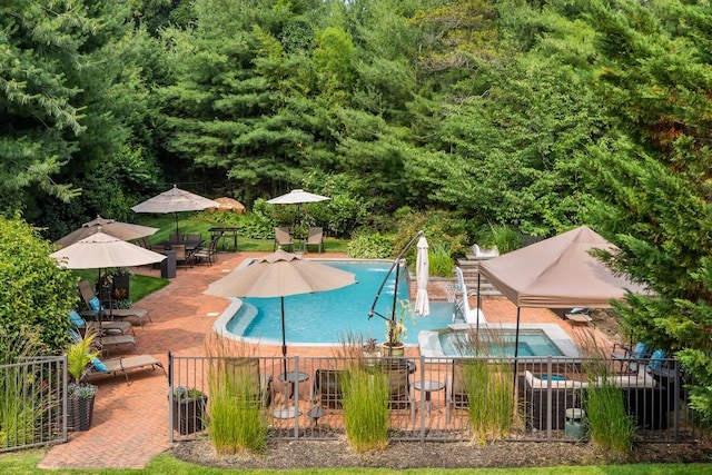 pool with a patio area and fence