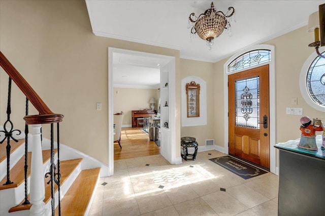 foyer entrance with baseboards, an inviting chandelier, light tile patterned floors, crown molding, and stairs
