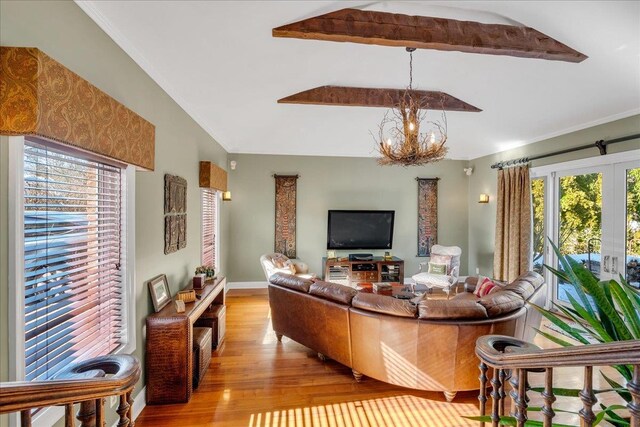 living room with an inviting chandelier, ornamental molding, and wood finished floors