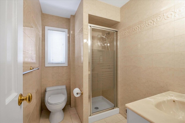 bathroom with toilet, tile patterned floors, tile walls, and a stall shower