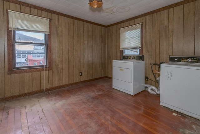 clothes washing area featuring hardwood / wood-style flooring, washer / clothes dryer, and laundry area