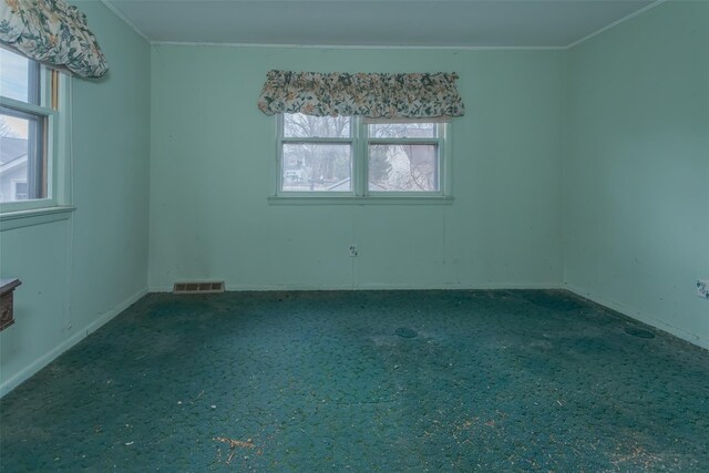 empty room with visible vents, carpet floors, and crown molding