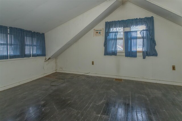 additional living space featuring lofted ceiling and hardwood / wood-style floors