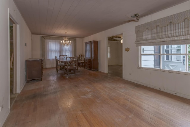 unfurnished dining area with an inviting chandelier, wood ceiling, and light wood finished floors