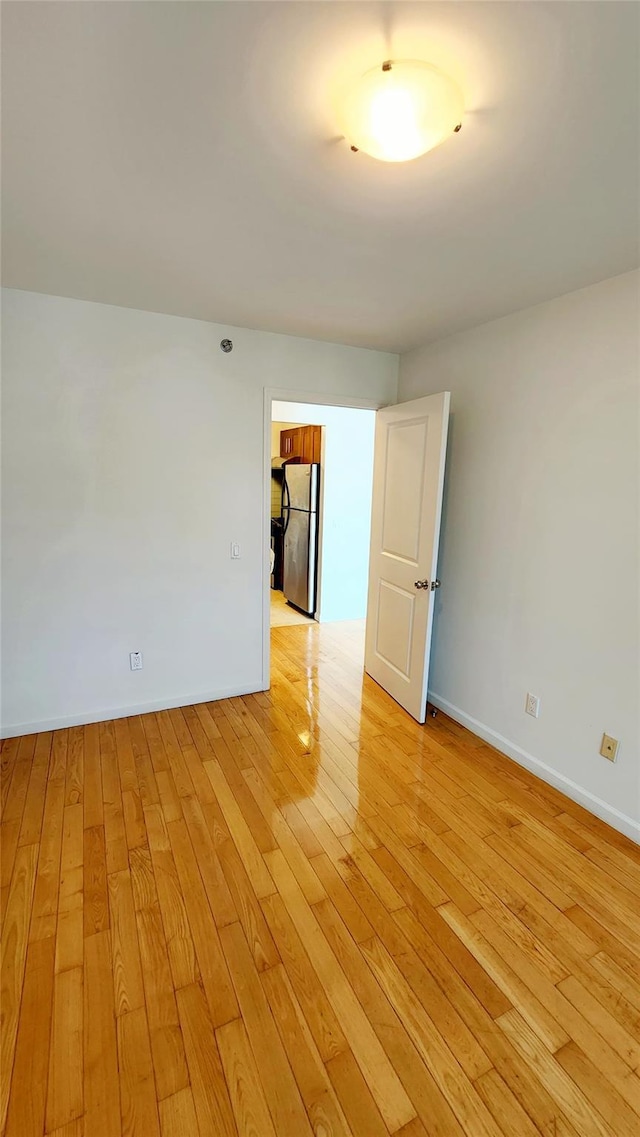 empty room with baseboards and light wood-style floors