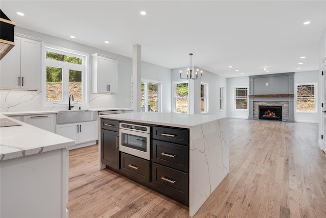 kitchen featuring a sink, light wood-type flooring, and white cabinets