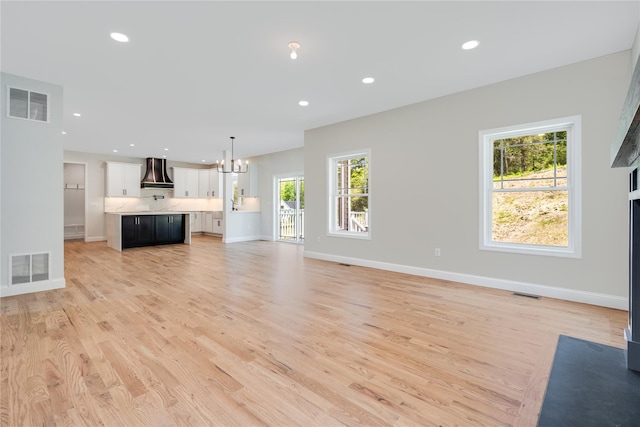 unfurnished living room with a notable chandelier, recessed lighting, and visible vents