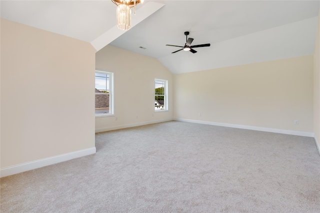 spare room with lofted ceiling, light colored carpet, baseboards, and ceiling fan