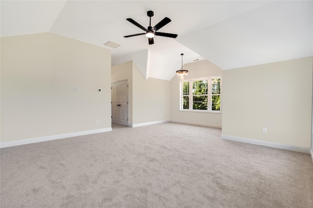 unfurnished room featuring baseboards, lofted ceiling, light colored carpet, and visible vents