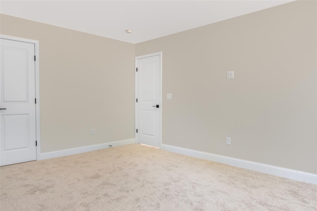 spare room with baseboards and carpet floors