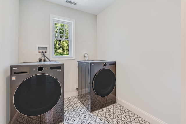 clothes washing area with visible vents, baseboards, laundry area, and washer and clothes dryer