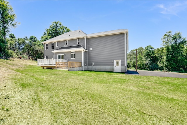 rear view of house featuring a deck and a yard