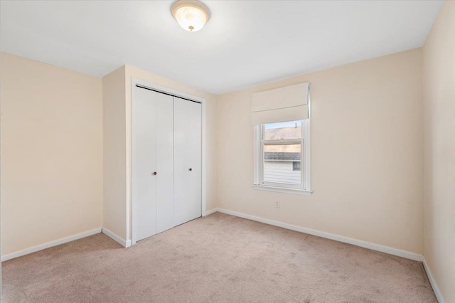 unfurnished bedroom featuring a closet, carpet floors, and baseboards