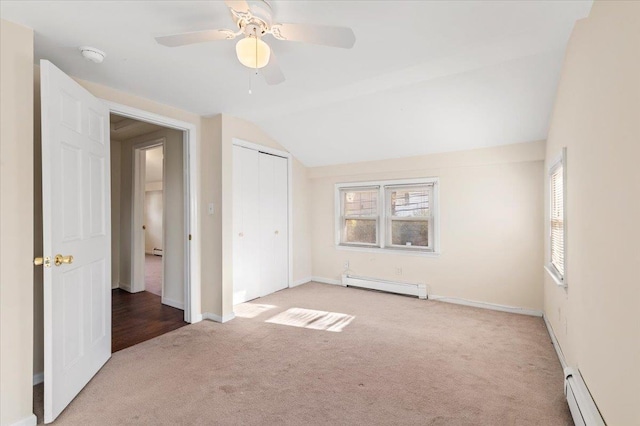 unfurnished bedroom featuring carpet, lofted ceiling, and a baseboard radiator