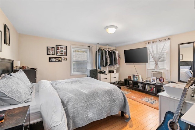 bedroom with cooling unit and wood-type flooring