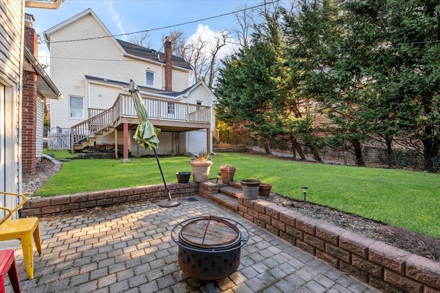 view of patio / terrace featuring a wooden deck, stairway, and an outdoor fire pit