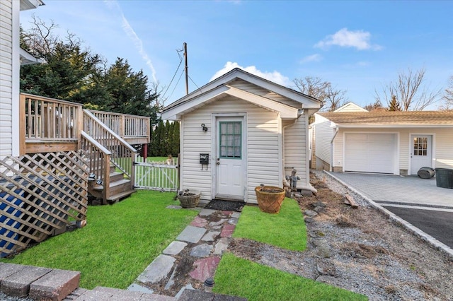 view of front of property with a front yard, a gate, fence, driveway, and an outdoor structure