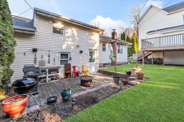 rear view of property featuring a fire pit, stairway, a chimney, a yard, and a patio area