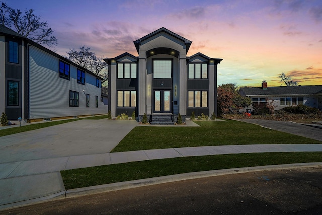 contemporary house featuring french doors, a front yard, and board and batten siding